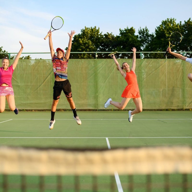 Mixed doubles tennis, players jump near the net , Tennis & Pickleball – New
